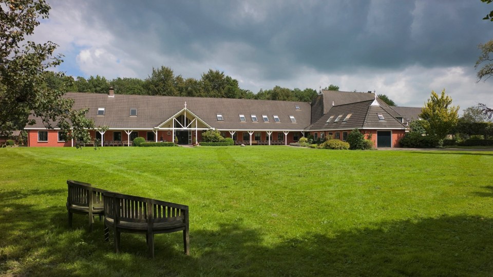 Wide view of the New Eden buildings and lawn with benches in the foreground